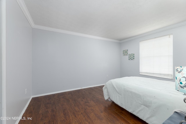 bedroom with ornamental molding and dark hardwood / wood-style floors