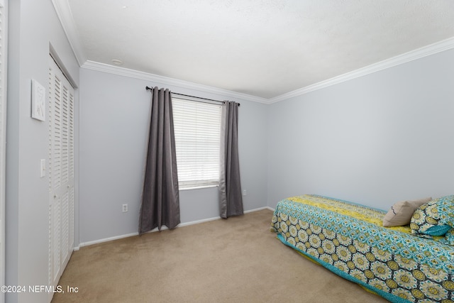 bedroom with crown molding, carpet floors, and a closet