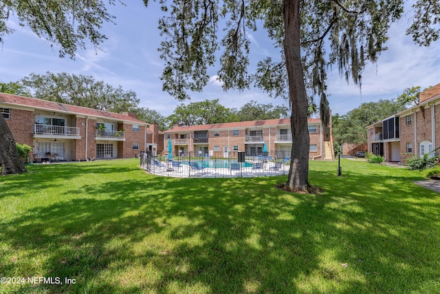 surrounding community featuring a swimming pool and a yard