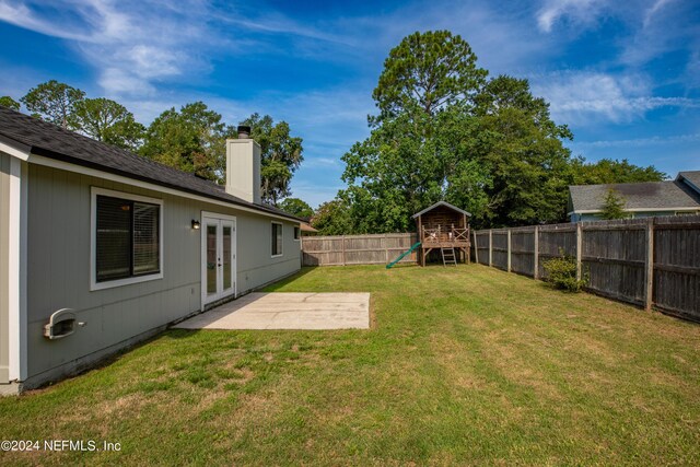 view of yard with a playground, a patio, and french doors