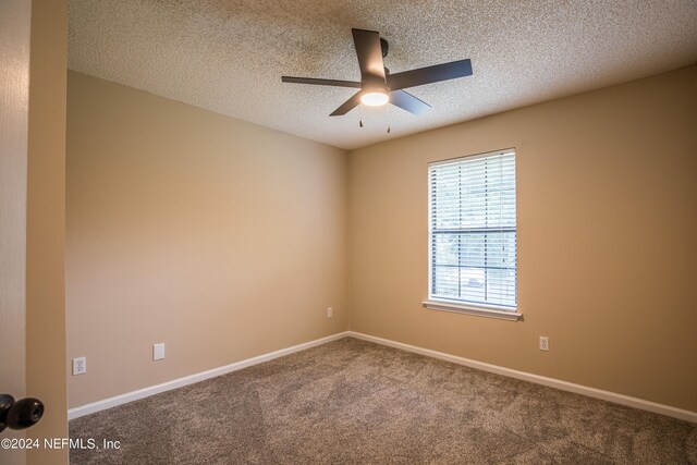 carpeted empty room featuring a textured ceiling and ceiling fan