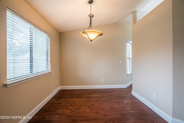 unfurnished room with lofted ceiling, hardwood / wood-style floors, and a textured ceiling