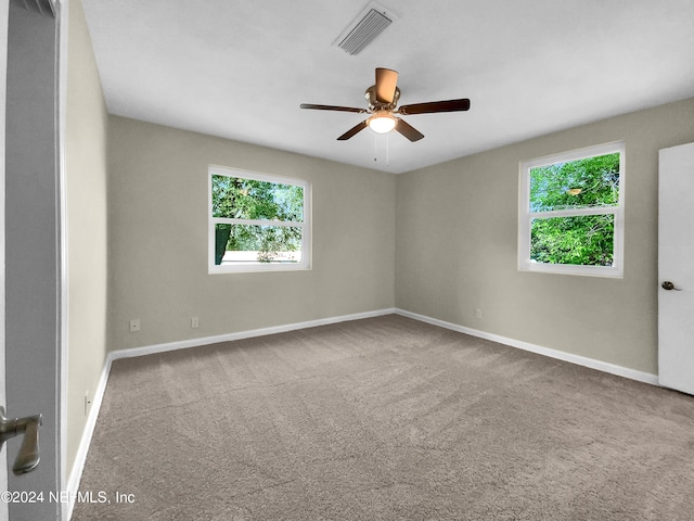 carpeted spare room with ceiling fan