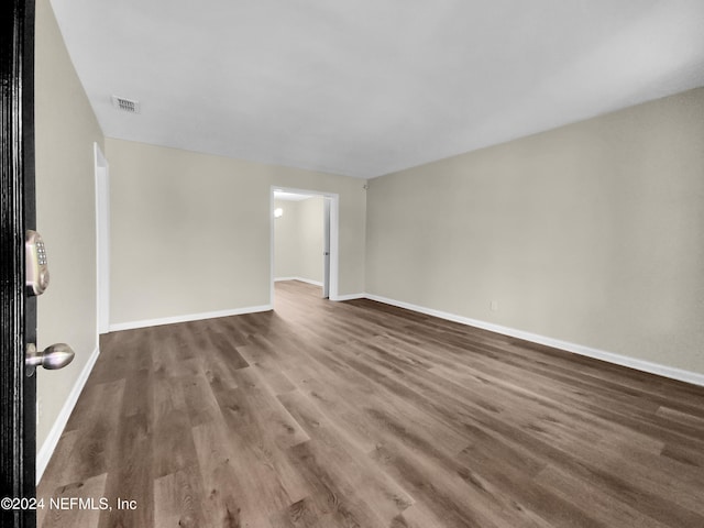 unfurnished room featuring dark wood-type flooring