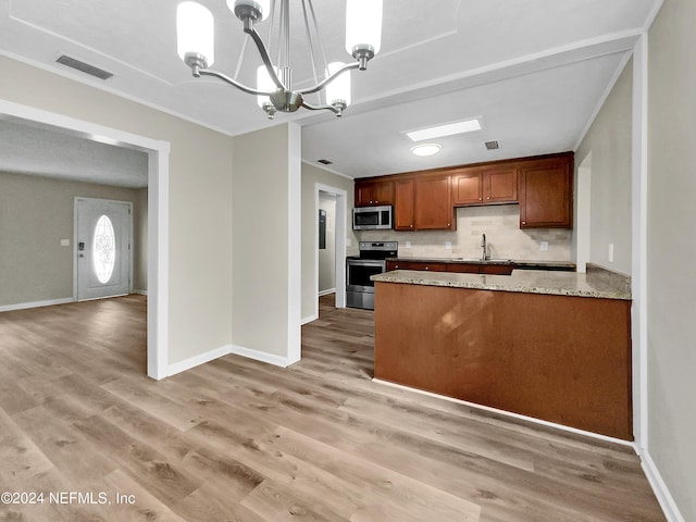 kitchen featuring light stone counters, appliances with stainless steel finishes, hardwood / wood-style floors, a chandelier, and pendant lighting