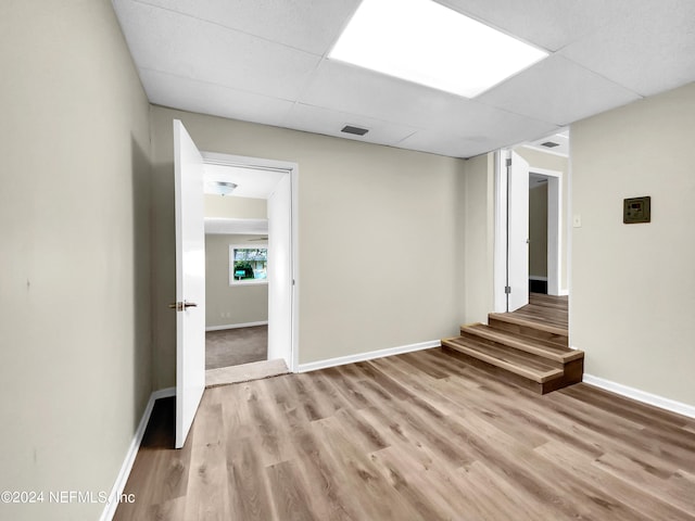 unfurnished room featuring light wood-type flooring and a paneled ceiling