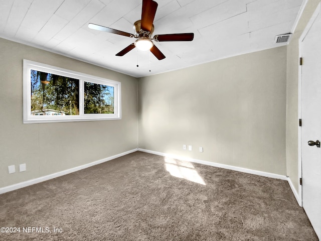 unfurnished room with ceiling fan and dark colored carpet