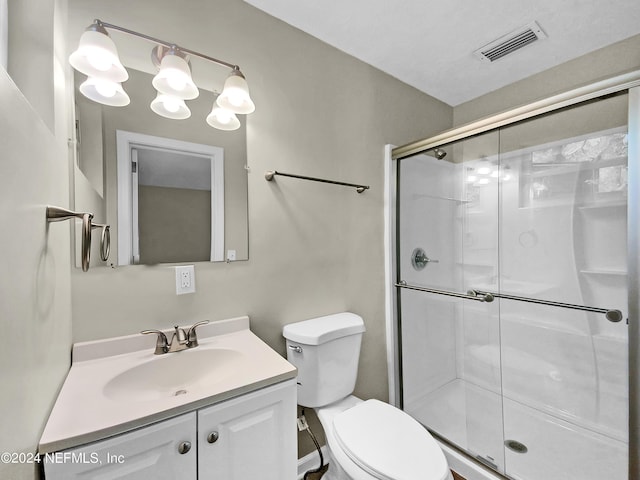 bathroom featuring vanity, toilet, and walk in shower