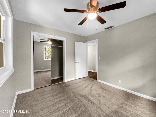 unfurnished bedroom with a closet, ceiling fan, and carpet flooring