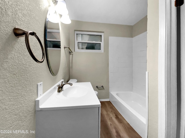 bathroom with hardwood / wood-style flooring, vanity, and shower / washtub combination