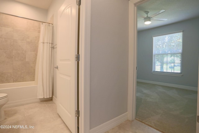 bathroom featuring ceiling fan, tile patterned floors, toilet, and shower / tub combo