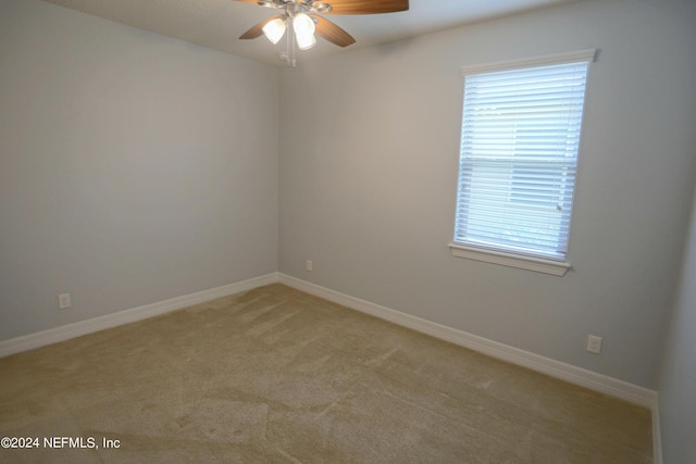 empty room featuring light colored carpet and ceiling fan