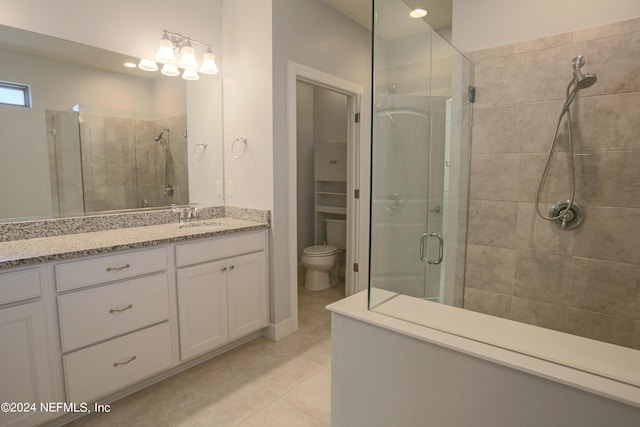 bathroom with an enclosed shower, vanity, tile patterned flooring, and toilet