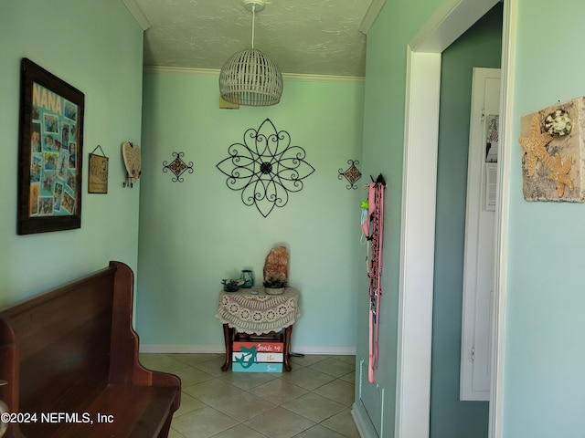 sitting room with light tile patterned flooring, ornamental molding, and a textured ceiling