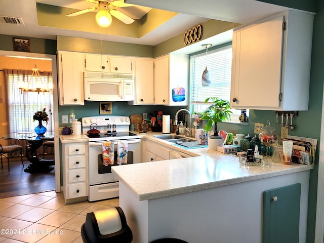 kitchen featuring sink, white cabinetry, a raised ceiling, kitchen peninsula, and white appliances