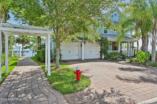 view of front of home featuring metal roof, a porch, decorative driveway, and a standing seam roof