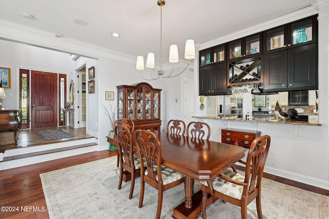 dining space featuring ornamental molding, baseboards, a notable chandelier, and light wood finished floors