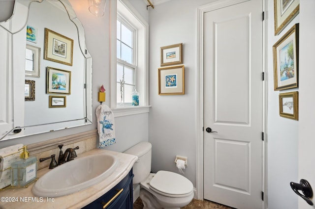 half bathroom with vanity and toilet