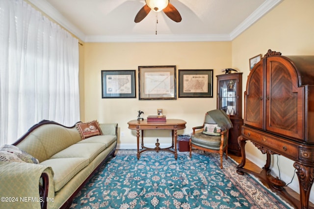 living area featuring ornamental molding, ceiling fan, and baseboards