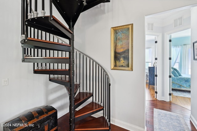 stairs with wood finished floors, visible vents, and baseboards