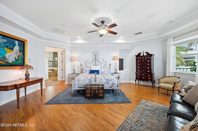 bedroom with baseboards, ornamental molding, visible vents, and light wood-style floors