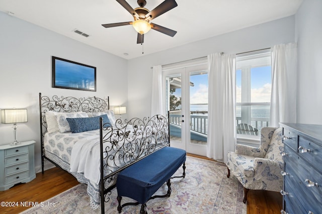 bedroom with ceiling fan, access to outside, wood finished floors, and visible vents