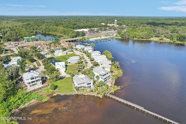 birds eye view of property featuring a water view and a wooded view