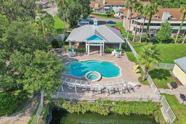 pool with a fenced backyard, a water view, a community hot tub, a patio area, and a pergola