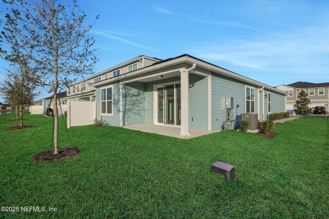 rear view of property with central AC, a patio area, and a lawn