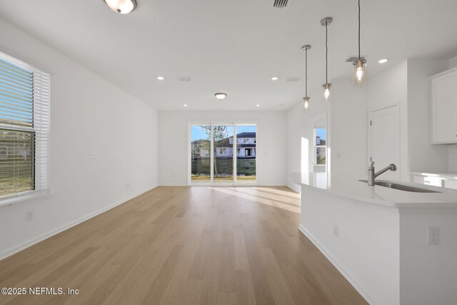 unfurnished living room featuring sink and light wood-type flooring