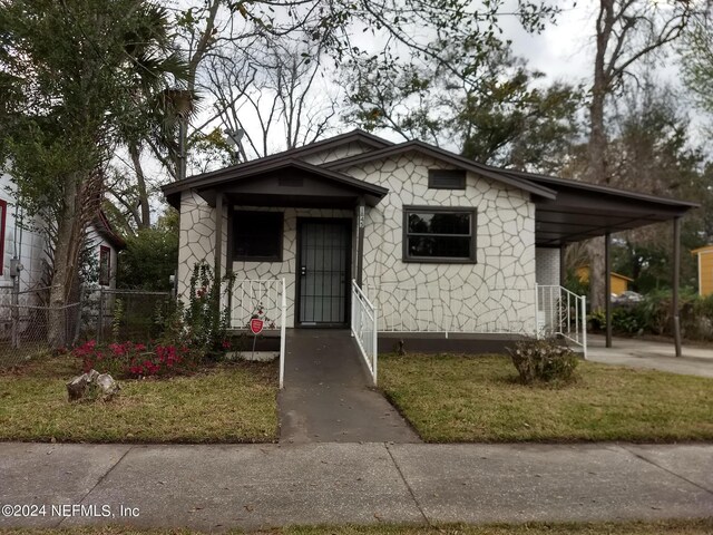 bungalow featuring a carport and a front yard