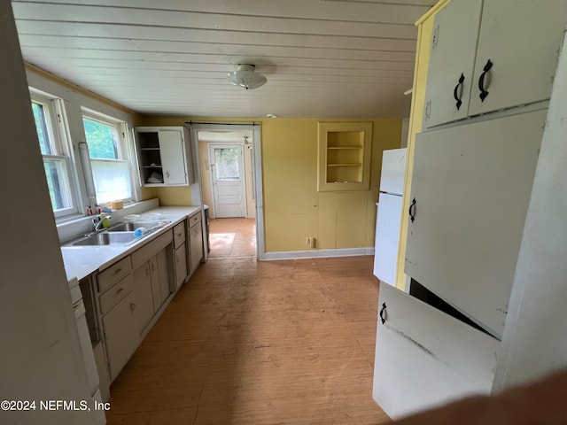 kitchen with built in features, sink, and light wood-type flooring