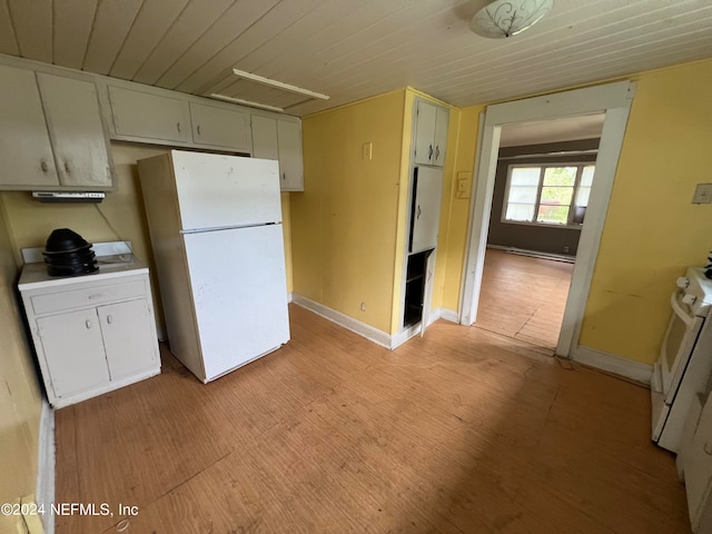 kitchen featuring white fridge, baseboard heating, light hardwood / wood-style flooring, and stove