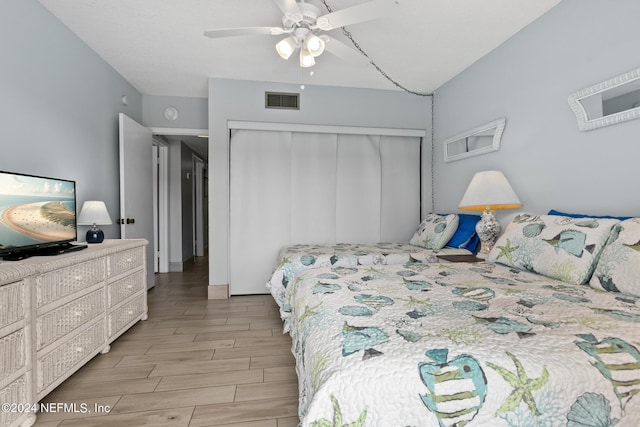 bedroom featuring ceiling fan, wood finish floors, a closet, and visible vents