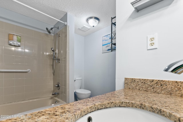 bathroom with visible vents, toilet,  shower combination, a textured ceiling, and vanity