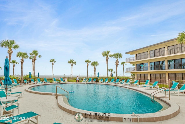 community pool featuring fence and a patio