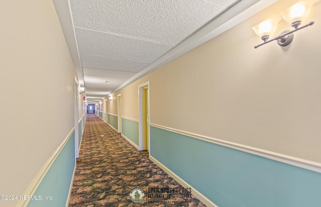 corridor with a textured ceiling and dark carpet