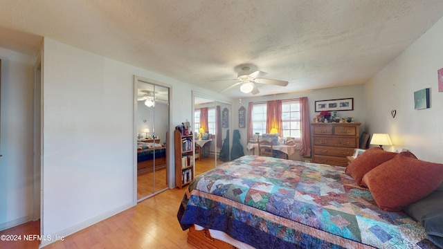 bedroom with ceiling fan, light hardwood / wood-style flooring, a textured ceiling, and a closet