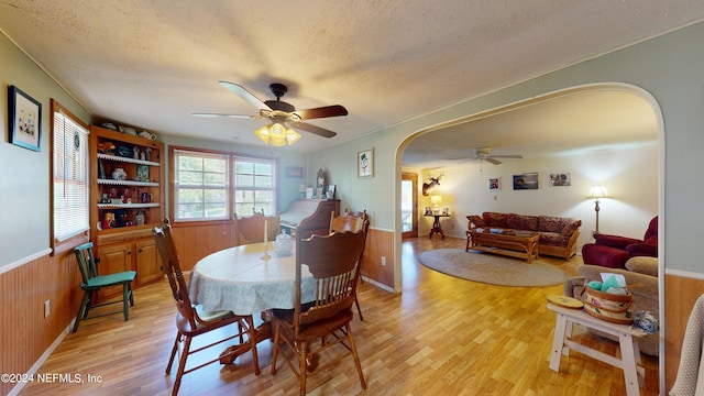 dining area with ceiling fan, light wood-type flooring, and a textured ceiling