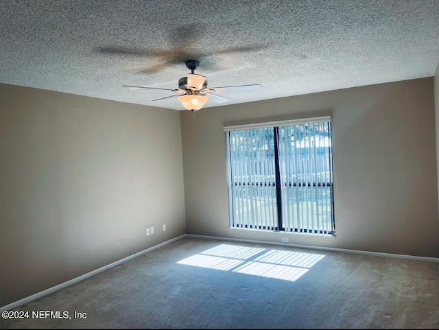 empty room with carpet flooring, a textured ceiling, and ceiling fan