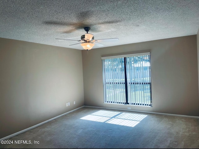carpeted spare room with baseboards, a textured ceiling, and ceiling fan