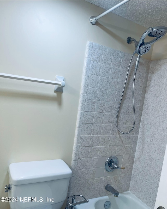 bathroom featuring toilet and tiled shower / bath