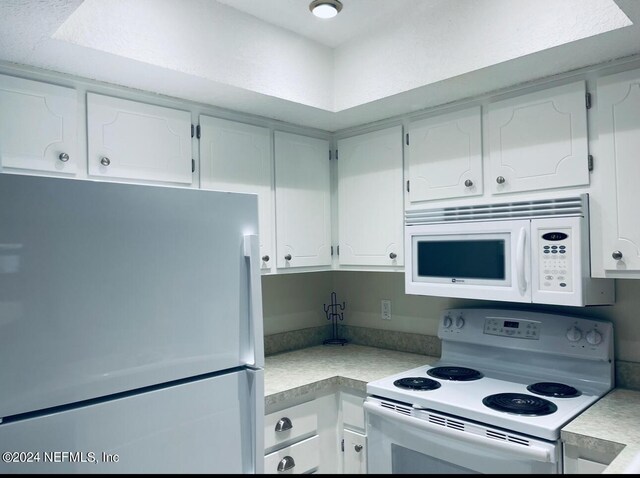 kitchen featuring white cabinetry and white appliances