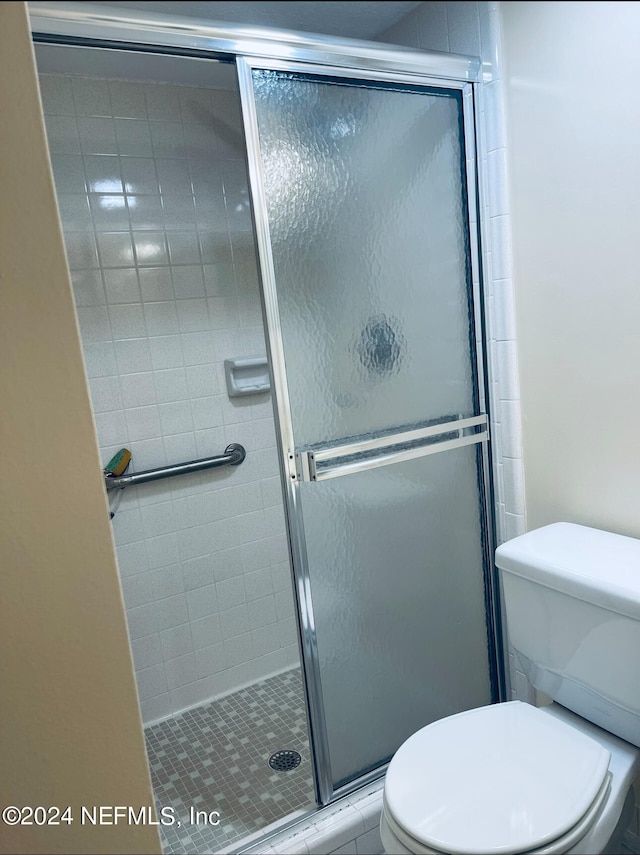 bathroom featuring an enclosed shower and toilet