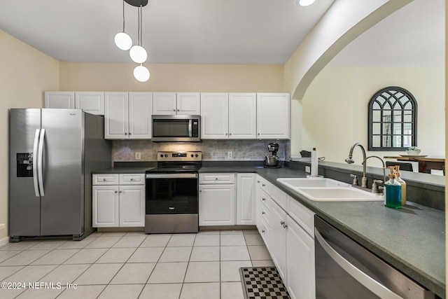 kitchen featuring sink, white cabinetry, hanging light fixtures, stainless steel appliances, and backsplash