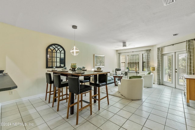 dining room featuring light tile patterned floors, french doors, a textured ceiling, and visible vents