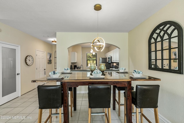 dining room with light tile patterned floors and an inviting chandelier