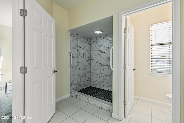 bathroom featuring a tile shower, tile patterned floors, and toilet