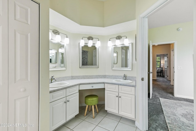 bathroom with double vanity, ensuite bath, a sink, and tile patterned floors