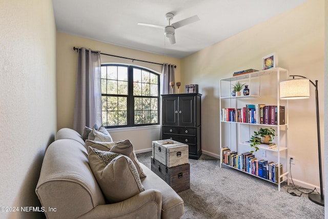 living area with ceiling fan, carpet, and baseboards